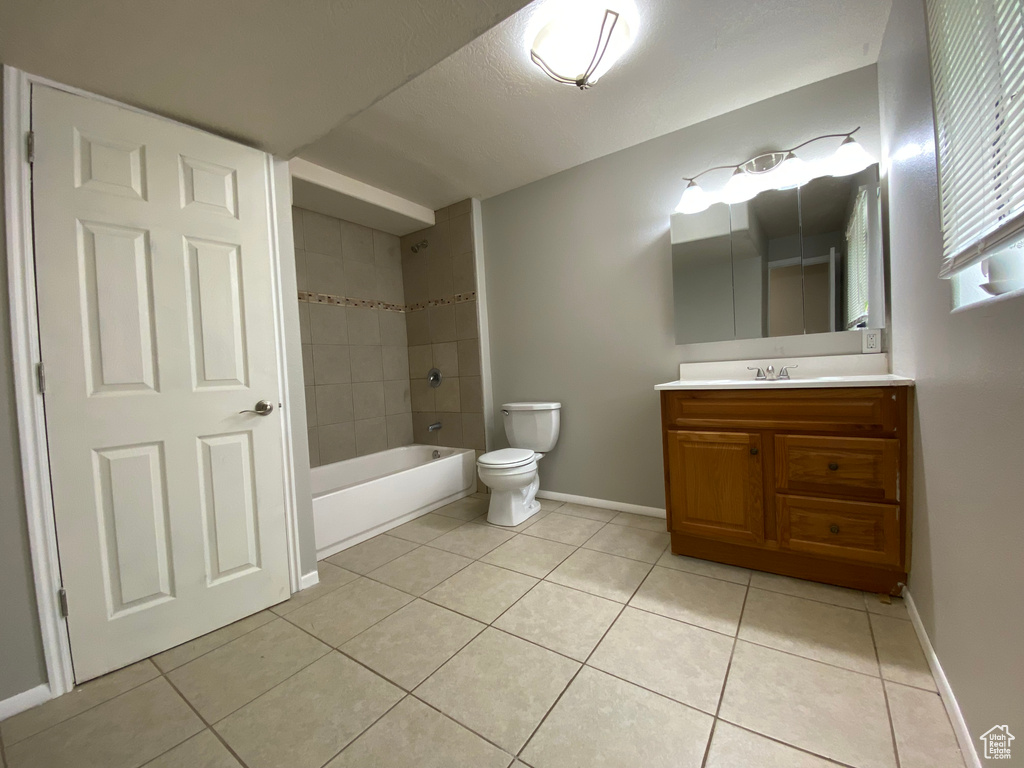 Full bathroom featuring tile floors, tiled shower / bath, toilet, and vanity