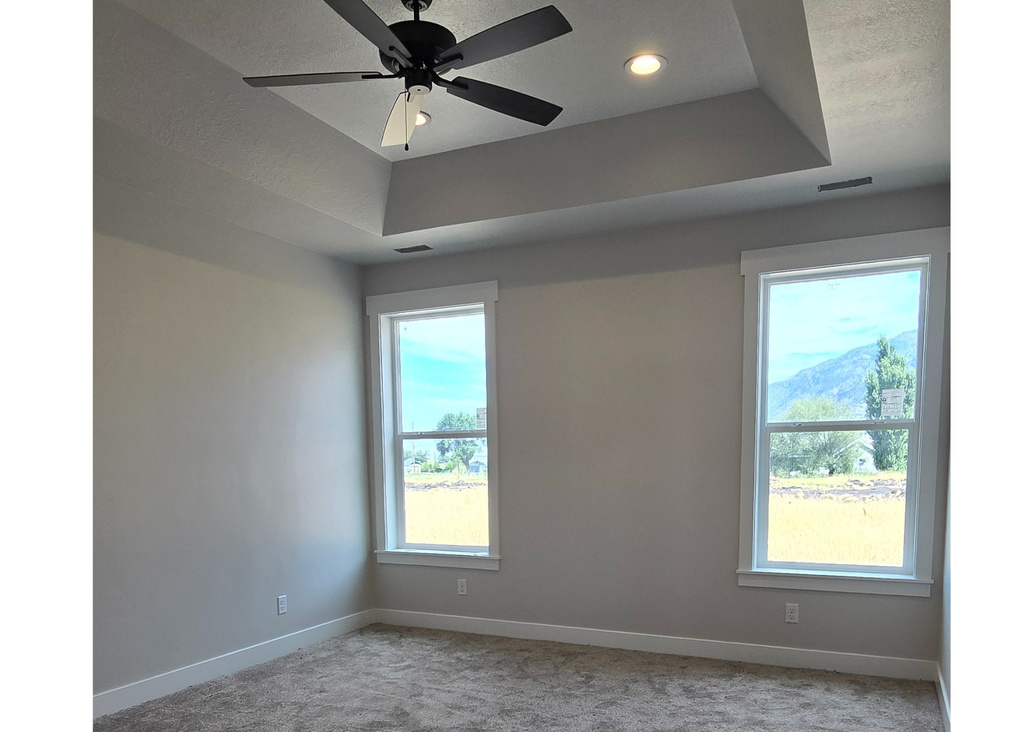 Empty room with plenty of natural light and ceiling fan