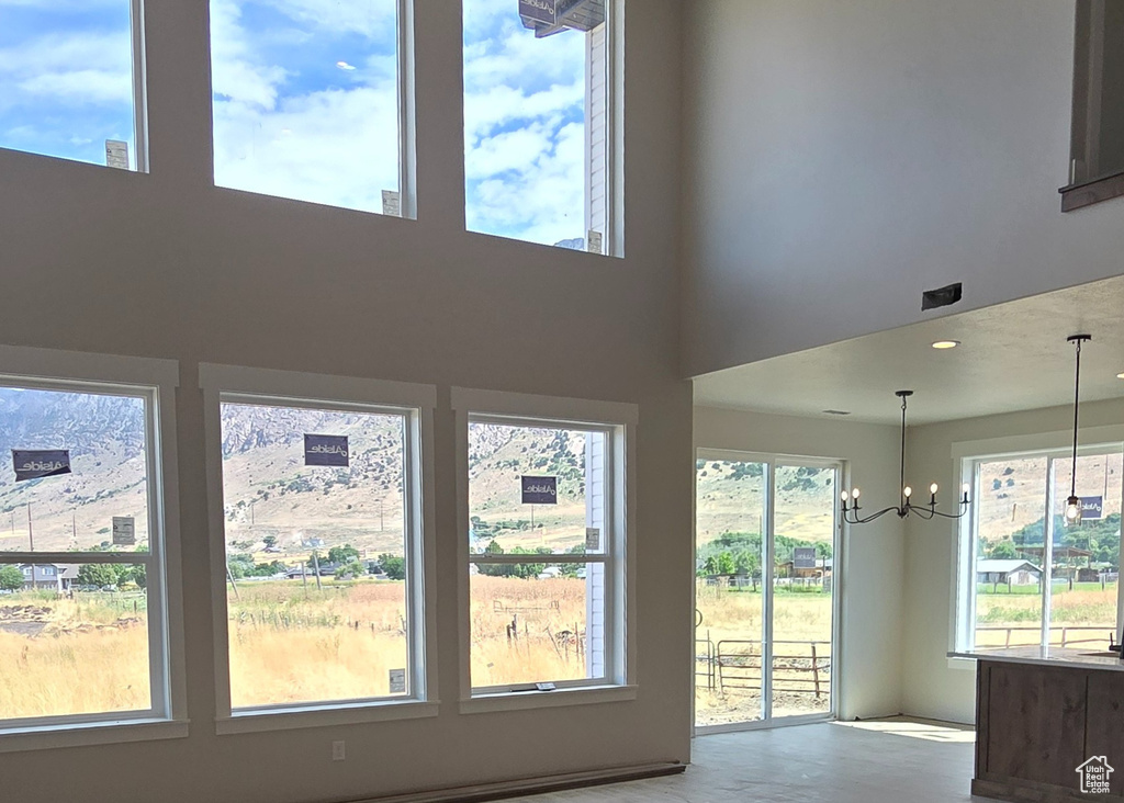 Interior space featuring light hardwood / wood-style floors, a high ceiling, and an inviting chandelier