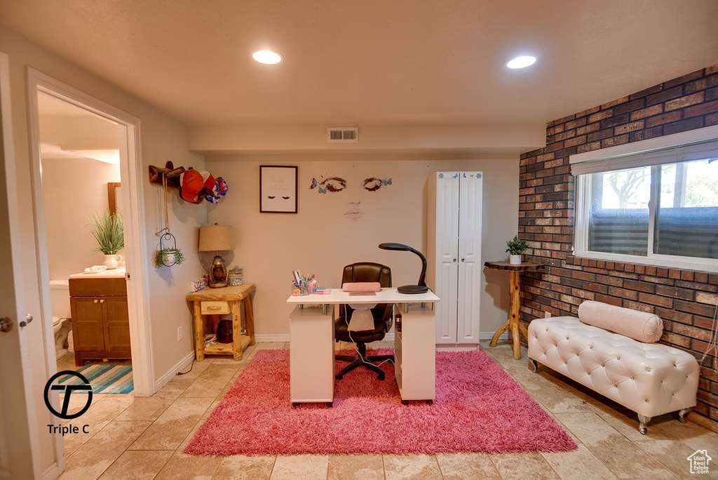Tiled office featuring brick wall
