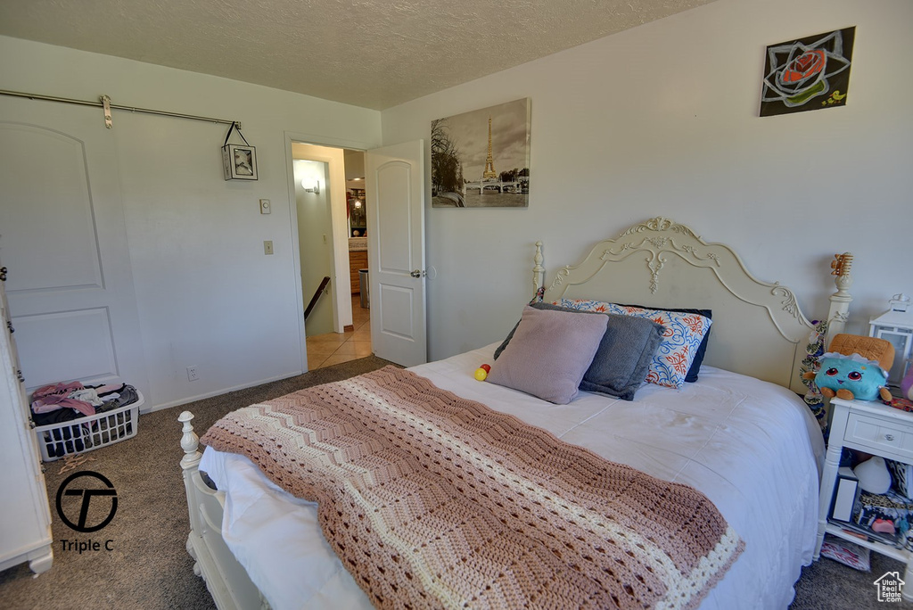 Carpeted bedroom with a textured ceiling