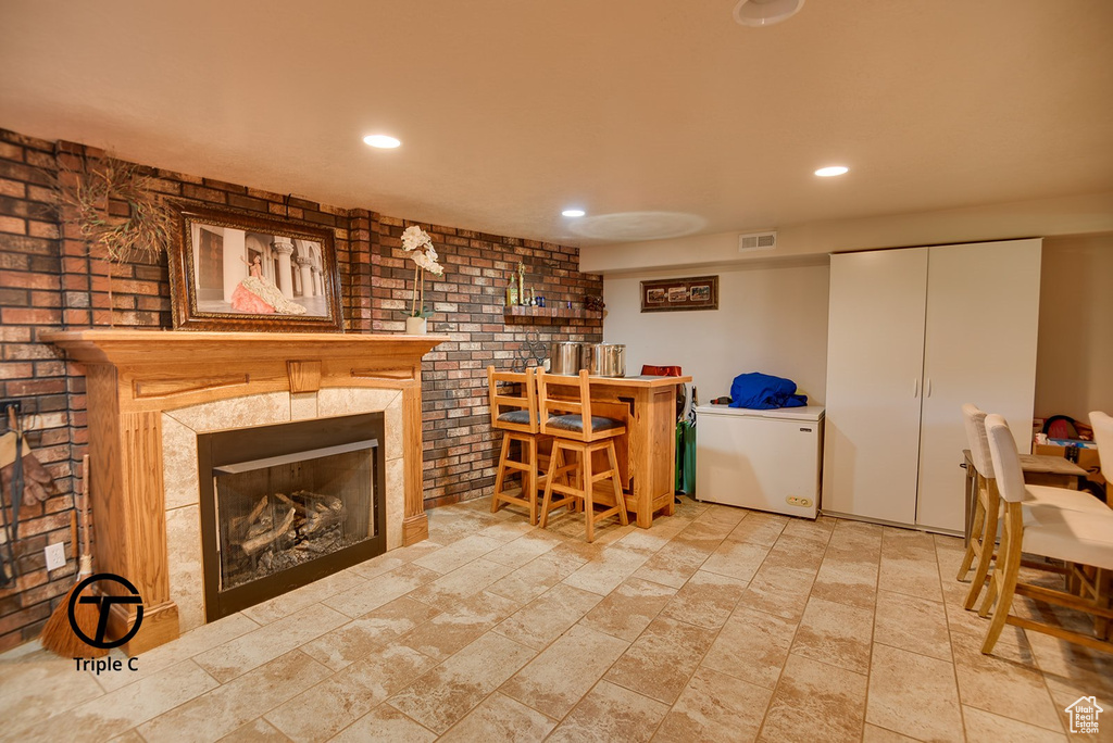 Interior space with light tile floors and a fireplace