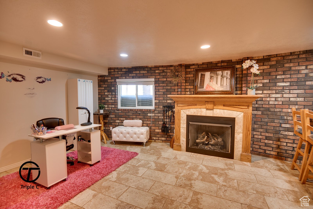 Tiled living room with a large fireplace and brick wall