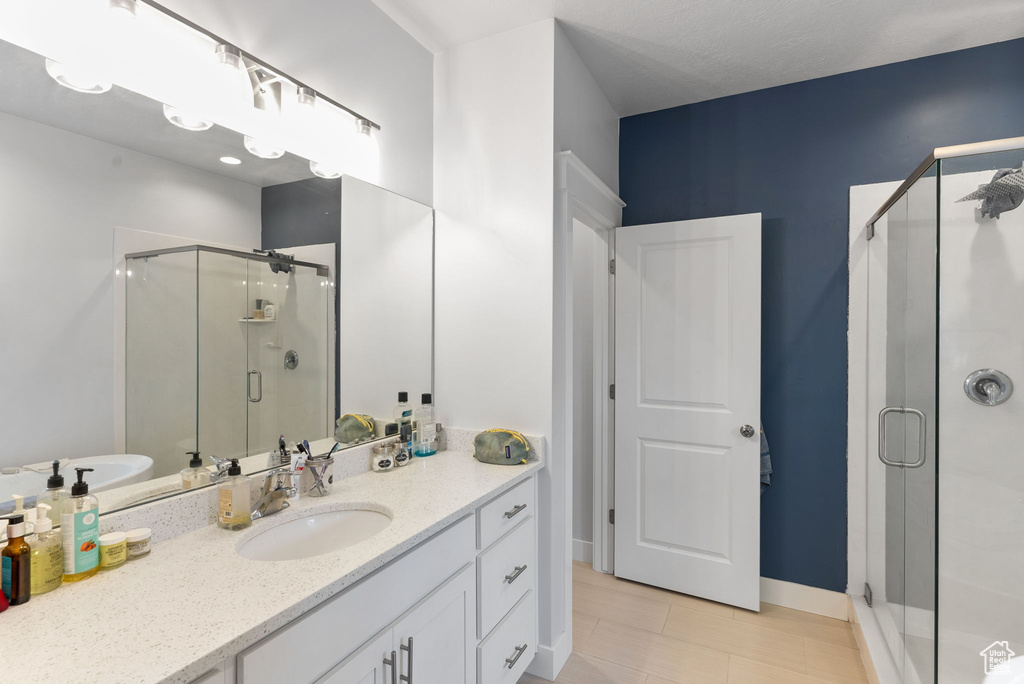 Bathroom featuring tile flooring, shower with separate bathtub, and oversized vanity