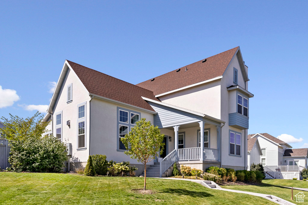 View of front of home with a front yard and a porch