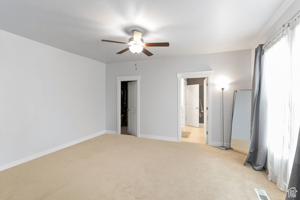 Spare room with ceiling fan and light colored carpet