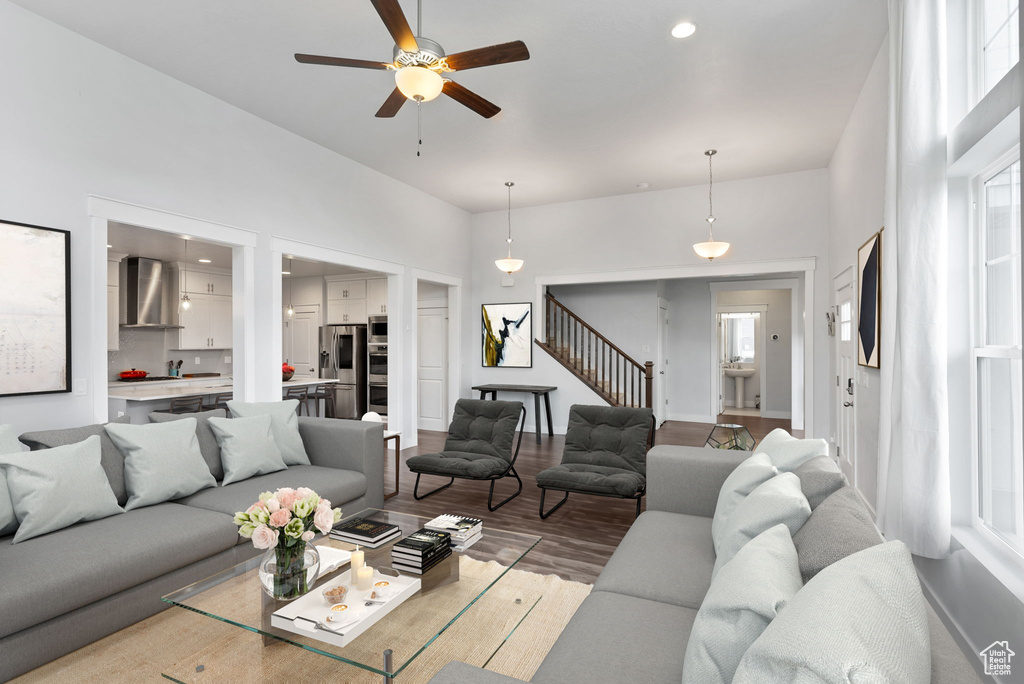 Living room featuring a towering ceiling, ceiling fan, and hardwood / wood-style floors