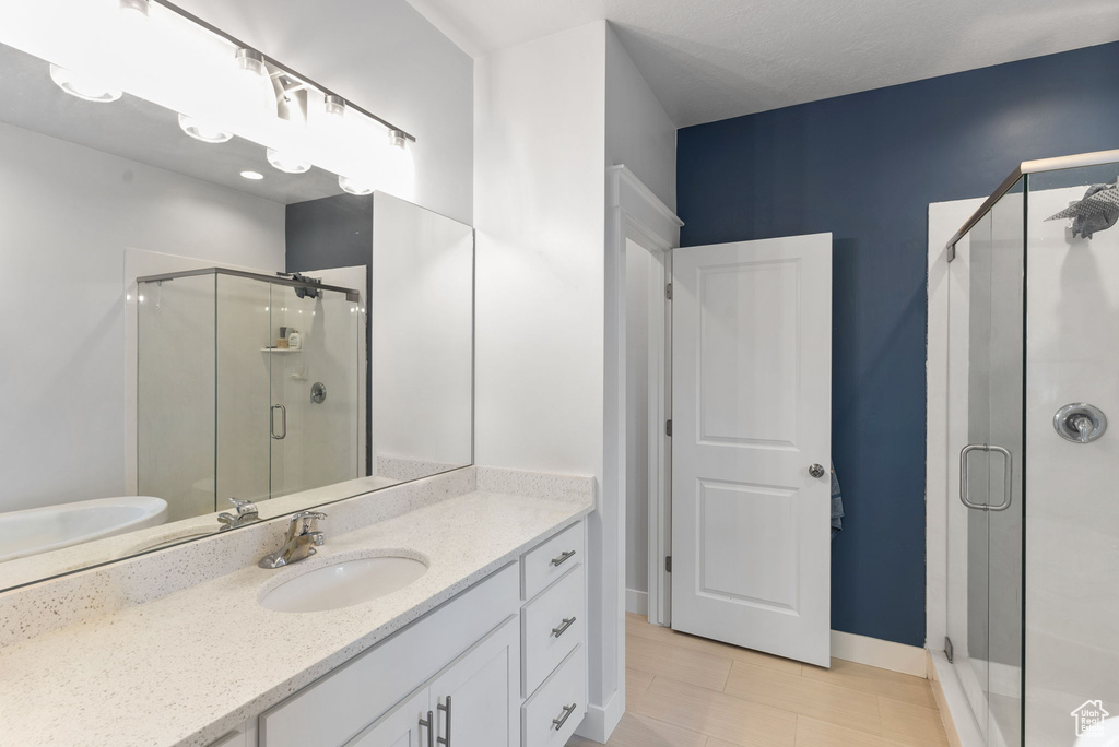 Bathroom featuring an enclosed shower, oversized vanity, and tile flooring