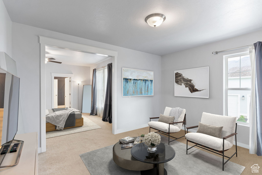 Sitting room with light carpet and ceiling fan