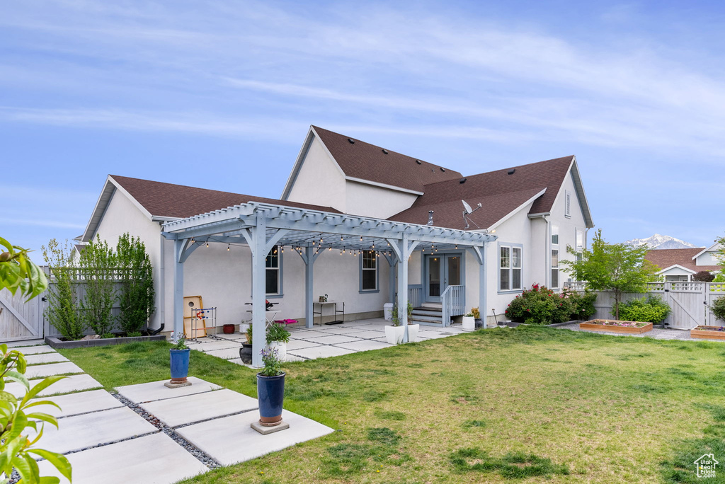 Back of property featuring a pergola, a lawn, and a patio