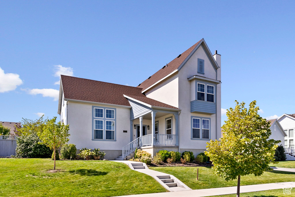 View of front of home with a porch and a front lawn