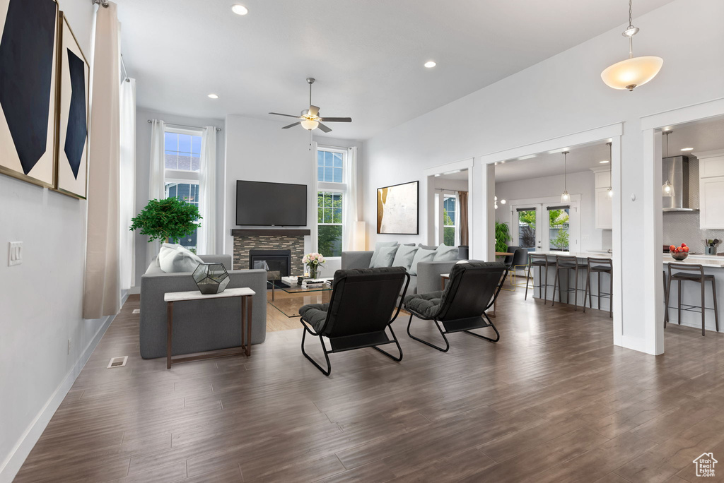 Living room with a fireplace, dark hardwood / wood-style floors, and ceiling fan