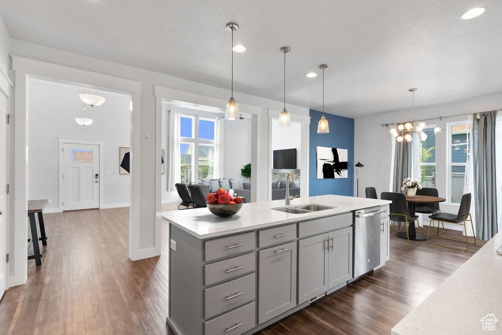 Kitchen featuring a healthy amount of sunlight, hanging light fixtures, dark wood-type flooring, and dishwasher