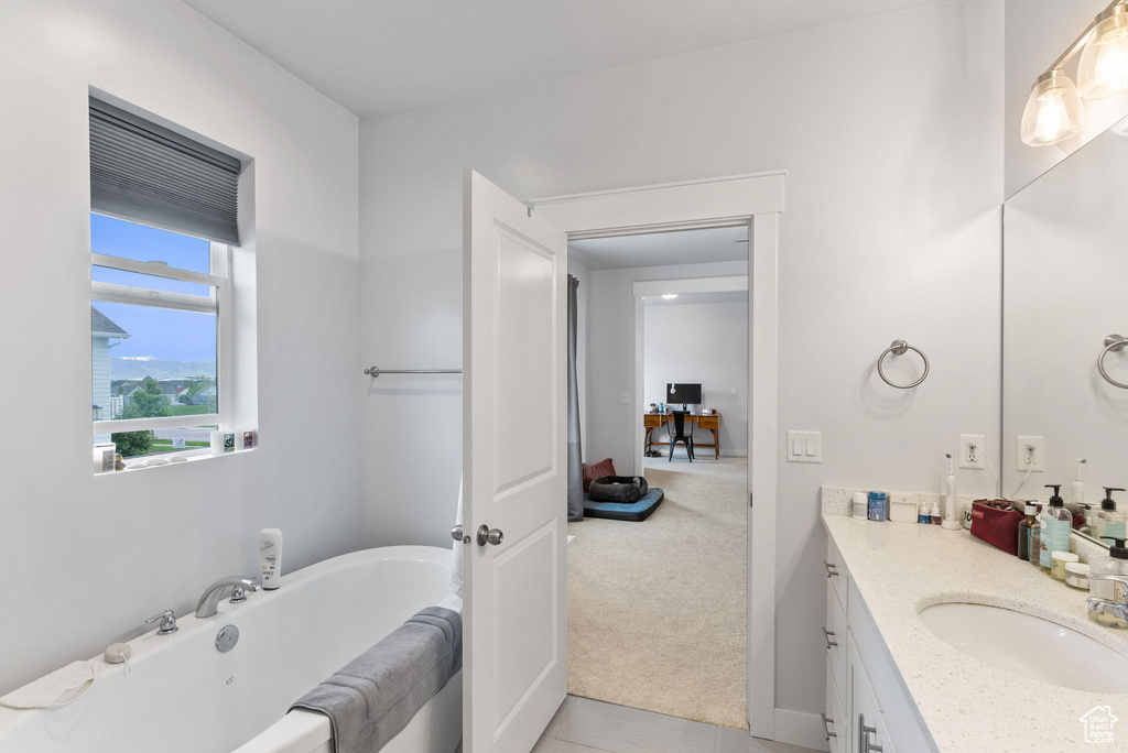 Bathroom with tile floors, a bathtub, and vanity with extensive cabinet space