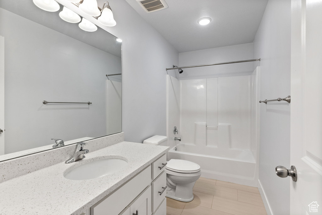 Full bathroom with vanity, toilet, tile floors, and shower / bathtub combination