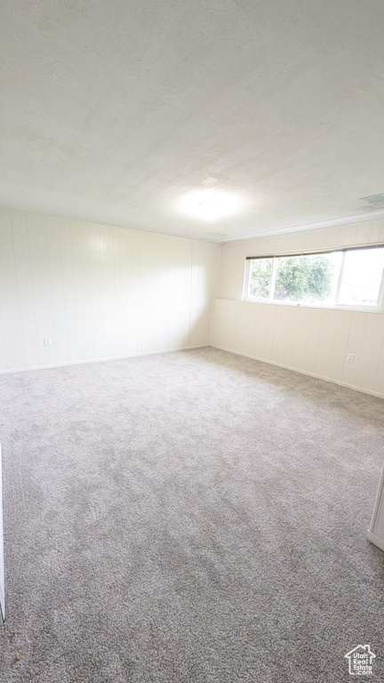 Carpeted spare room featuring a textured ceiling