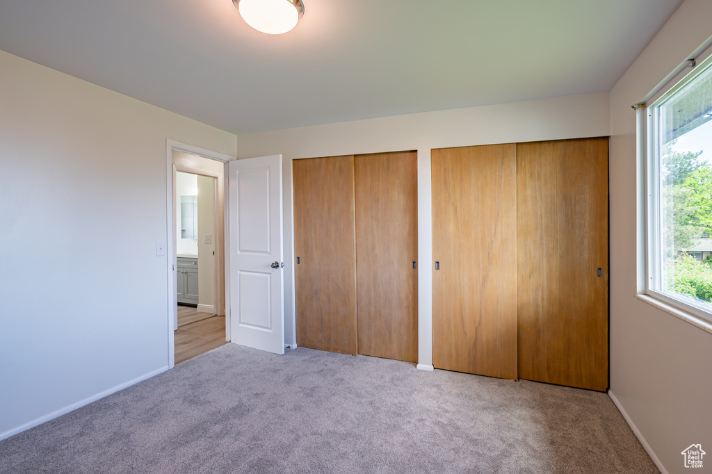 Unfurnished bedroom featuring multiple closets and light carpet