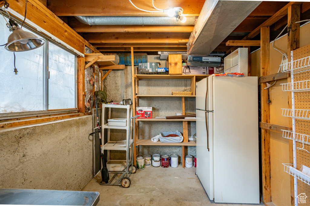 Basement featuring white fridge