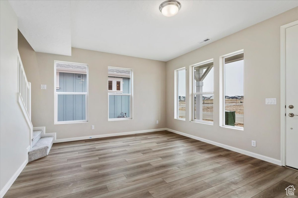 Empty room featuring a wealth of natural light and light hardwood / wood-style flooring