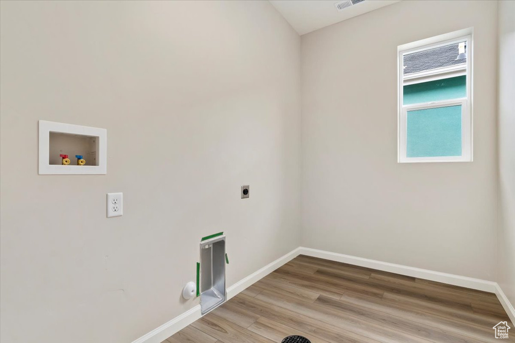 Clothes washing area with hookup for a washing machine, hardwood / wood-style floors, and electric dryer hookup