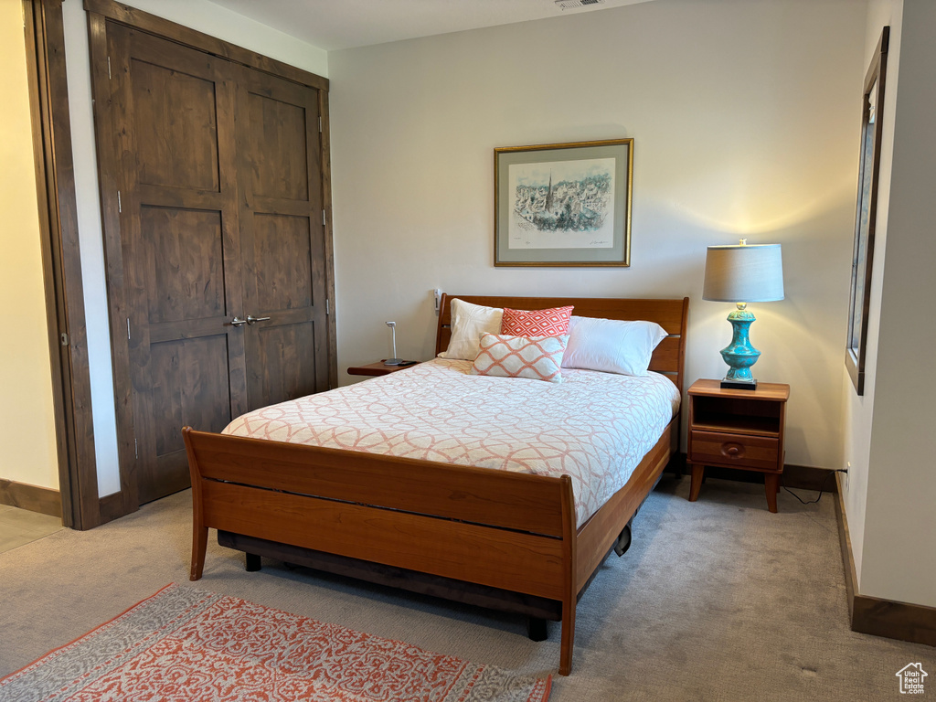 Carpeted bedroom with a closet