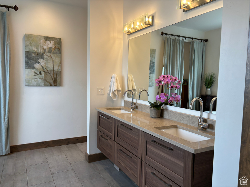 Bathroom with tile flooring and double sink vanity