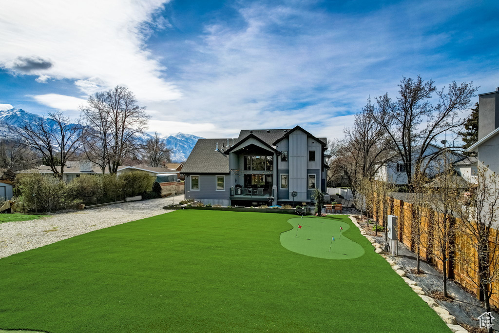 View of front of house with a mountain view and a front lawn