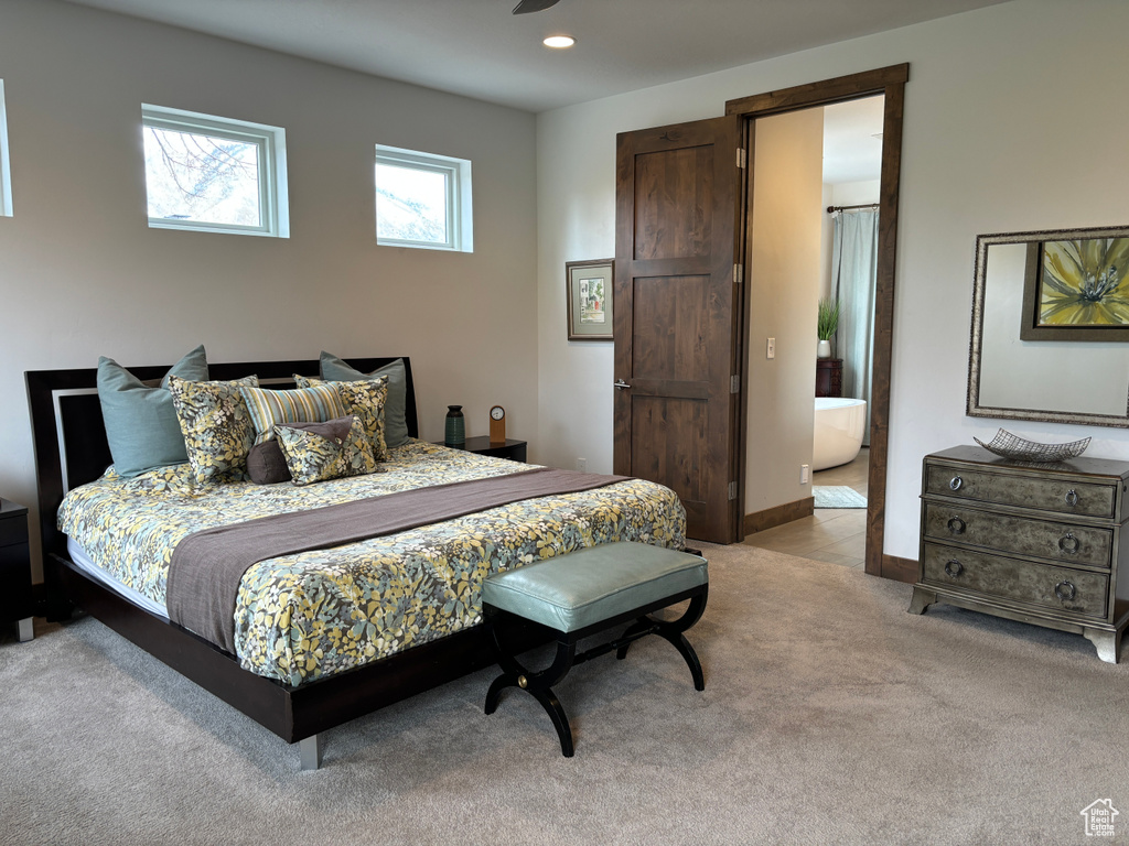 Carpeted bedroom featuring ensuite bath