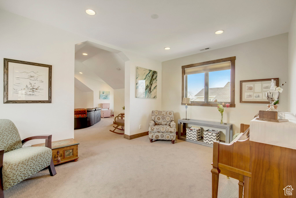 Living area with carpet and lofted ceiling