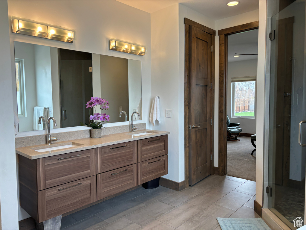 Bathroom with walk in shower, dual bowl vanity, and tile flooring