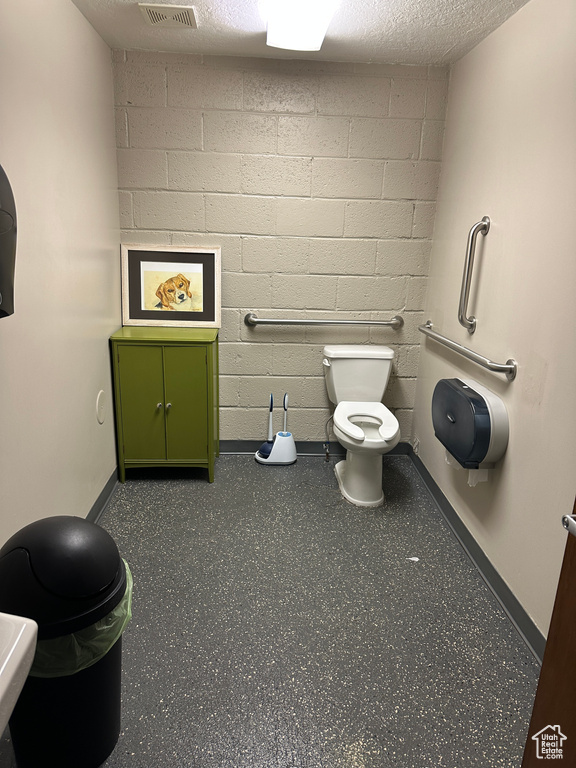 Bathroom featuring a textured ceiling and toilet