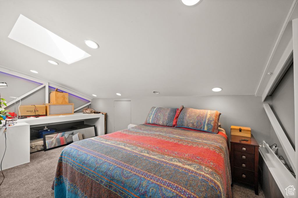 Bedroom with carpet flooring and lofted ceiling with skylight