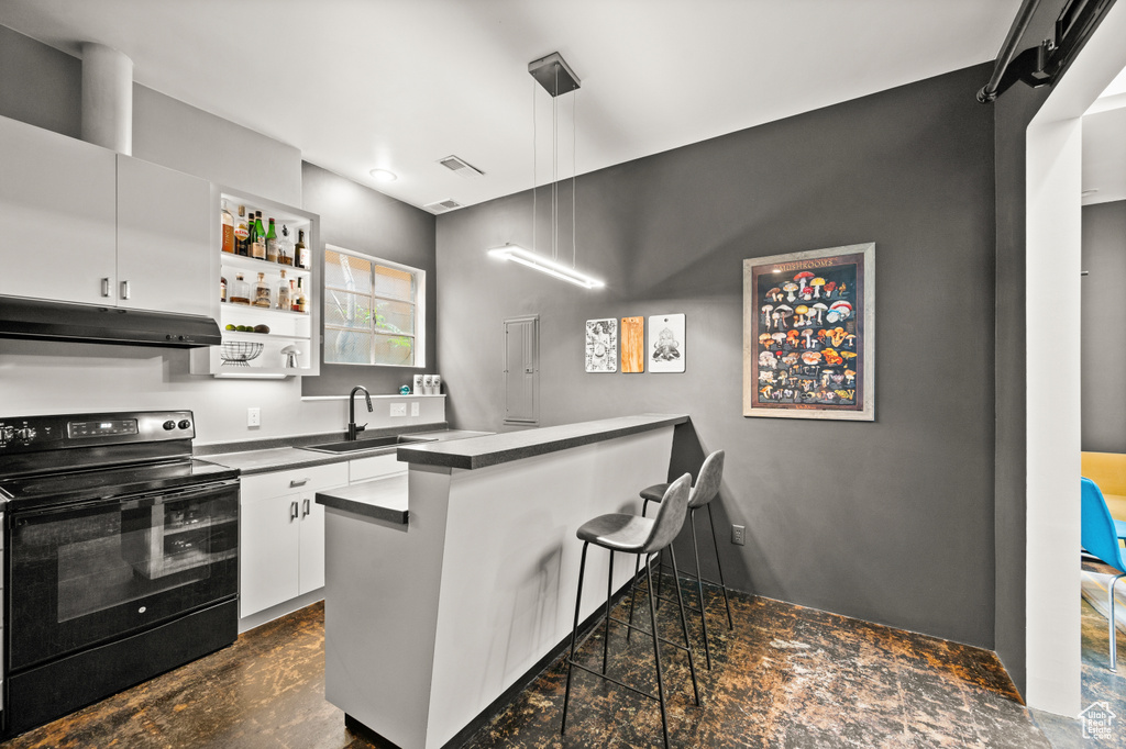 Kitchen featuring white cabinetry, decorative light fixtures, sink, and black / electric stove