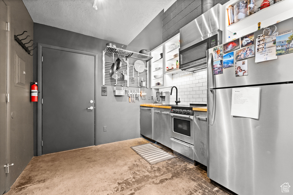 Kitchen featuring appliances with stainless steel finishes, sink, and concrete floors