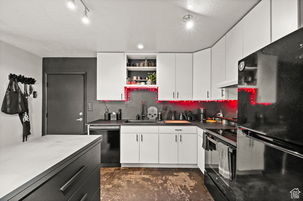 Kitchen featuring black appliances, backsplash, white cabinetry, and custom exhaust hood