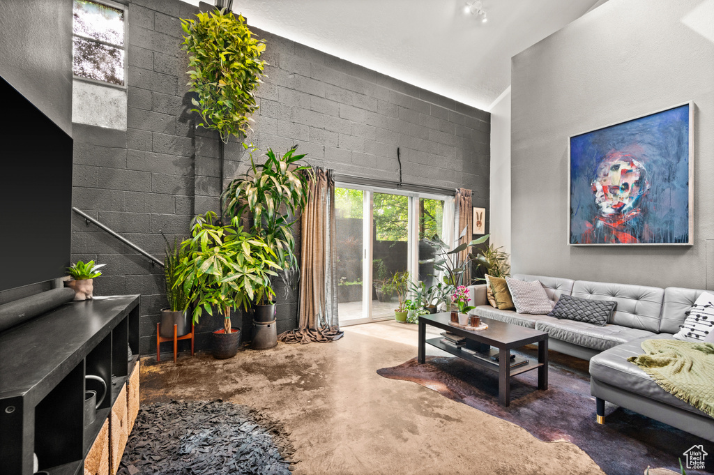 Living room featuring a towering ceiling and concrete floors