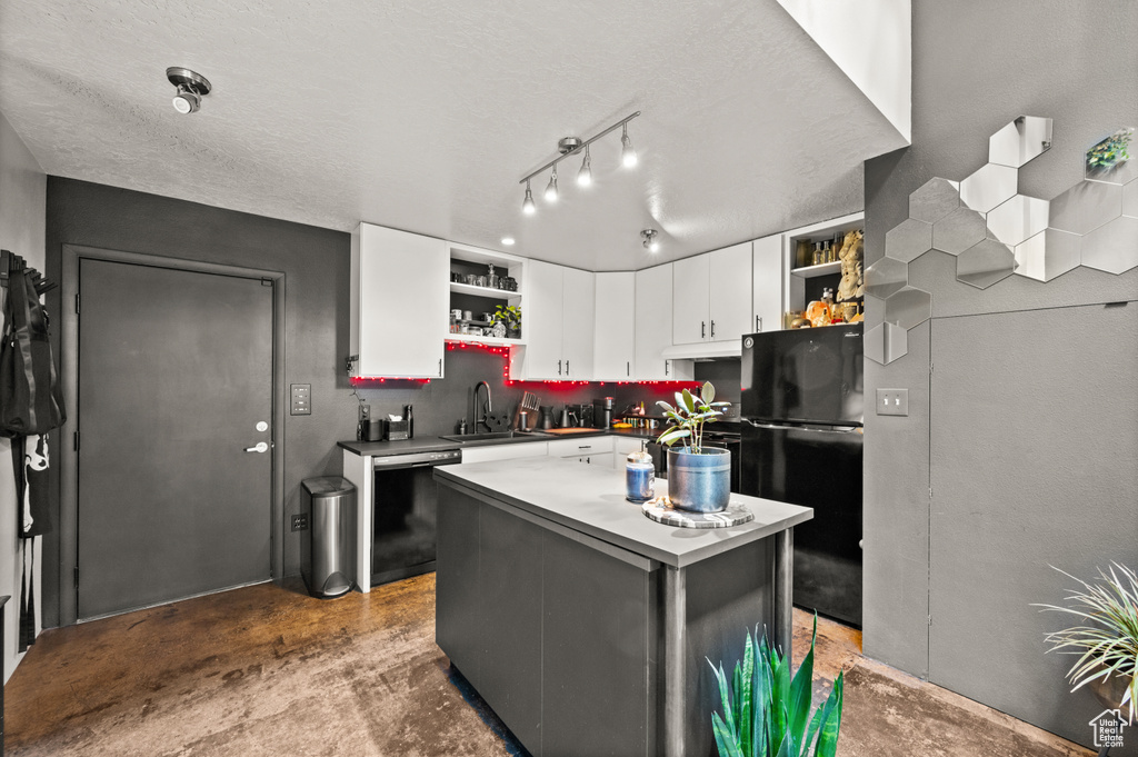 Kitchen featuring rail lighting, white cabinetry, a center island, black appliances, and sink