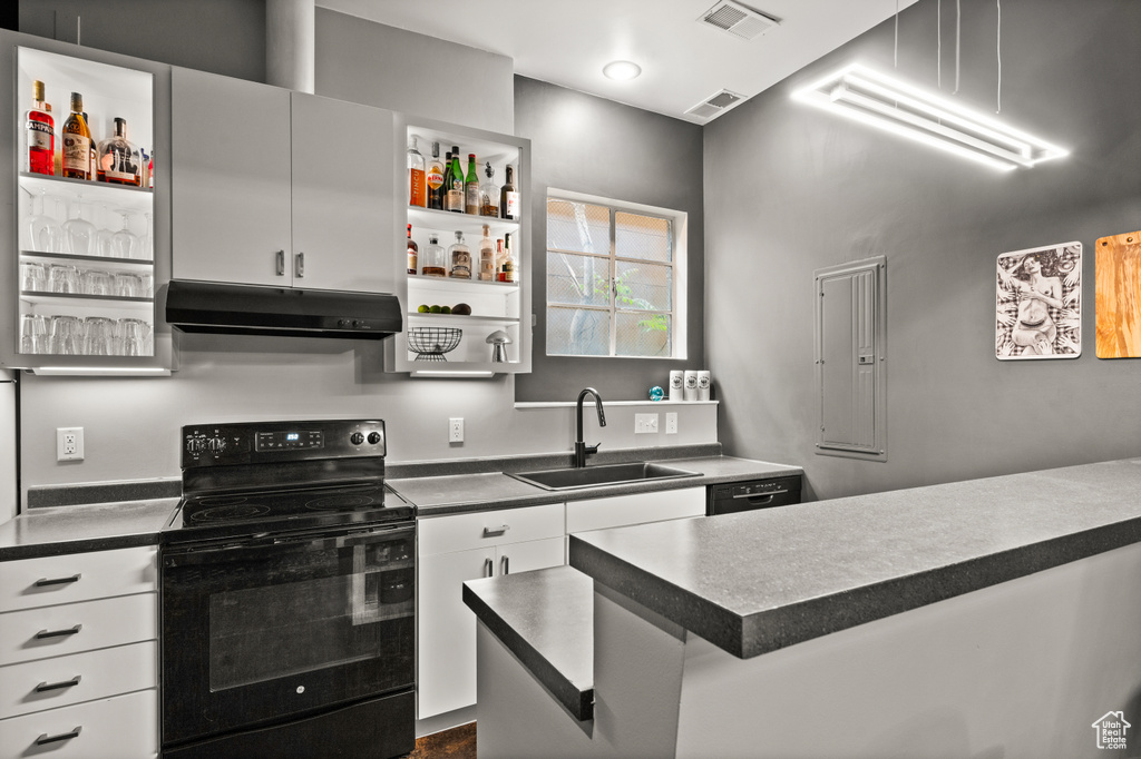 Kitchen featuring electric range, sink, black dishwasher, and white cabinets