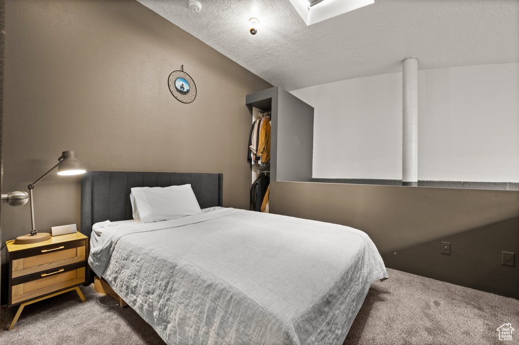 Bedroom with a textured ceiling and carpet flooring