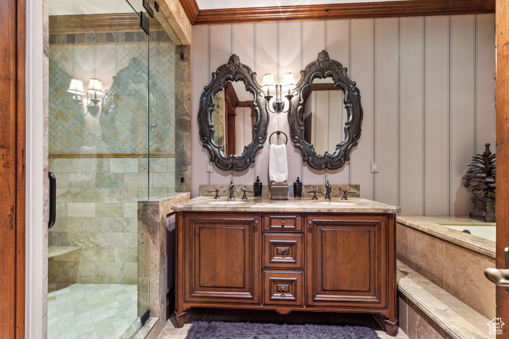 Bathroom featuring shower with separate bathtub, oversized vanity, and dual sinks