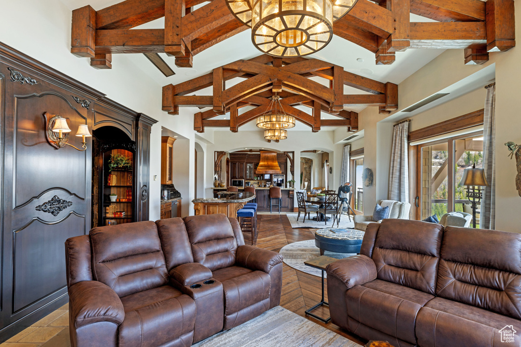 Living room with high vaulted ceiling, beam ceiling, and a chandelier