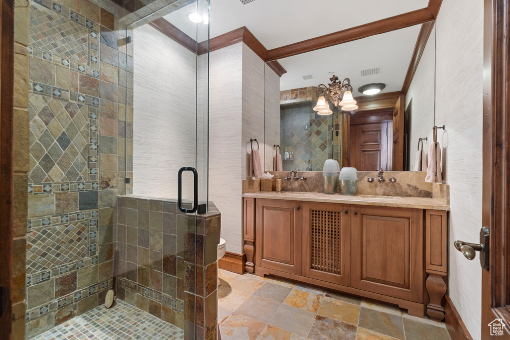 Bathroom with crown molding, an enclosed shower, double sink, and oversized vanity