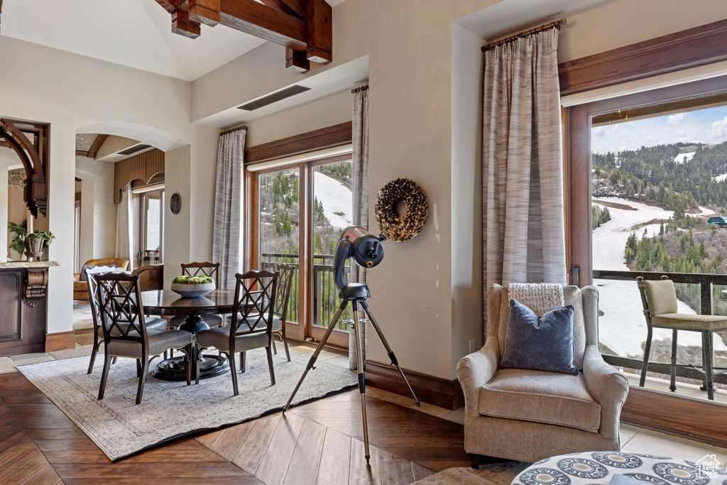 Dining space featuring beamed ceiling and parquet flooring