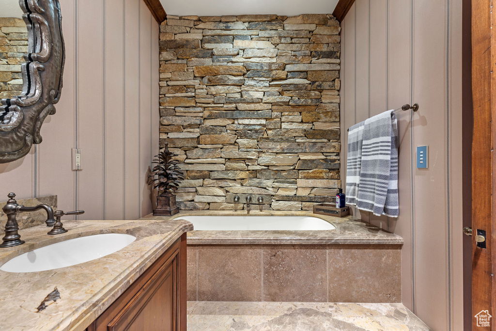 Bathroom with tiled tub and vanity