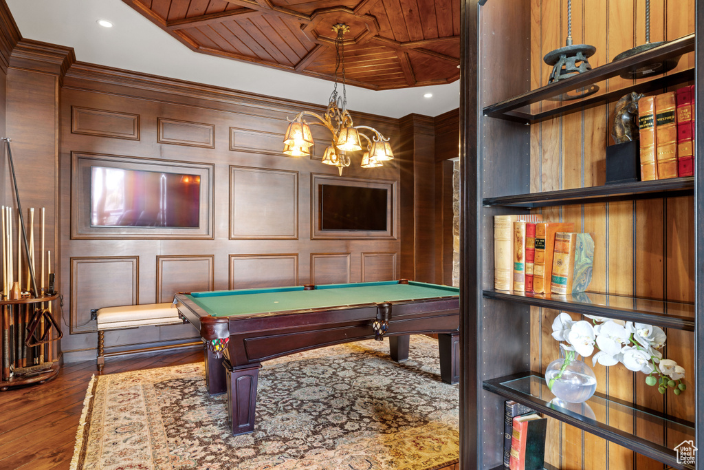 Game room with wood walls, hardwood / wood-style flooring, wooden ceiling, ornamental molding, and pool table