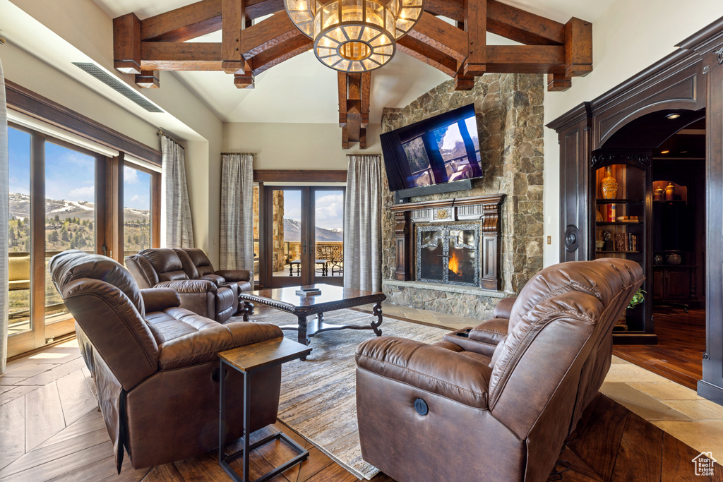 Living room with a fireplace, tile flooring, beam ceiling, high vaulted ceiling, and french doors