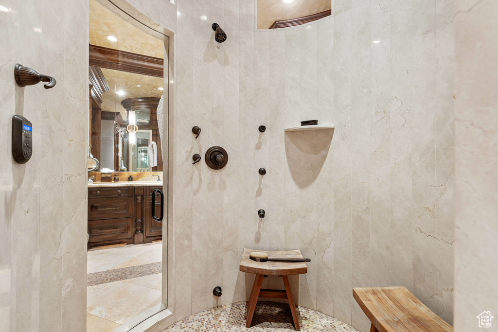 Bathroom with tile floors, a shower, and vanity