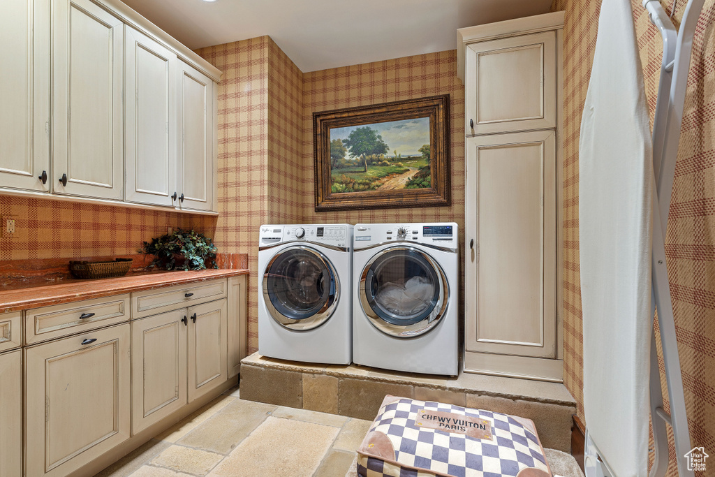 Laundry area featuring washer and clothes dryer and cabinets