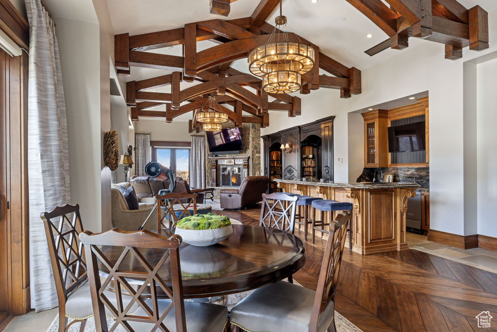 Dining room with a towering ceiling, parquet floors, and a chandelier