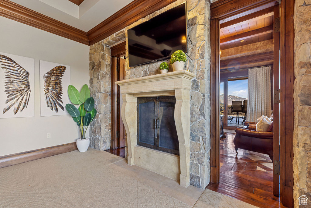 Living room with crown molding, a fireplace, and hardwood / wood-style flooring